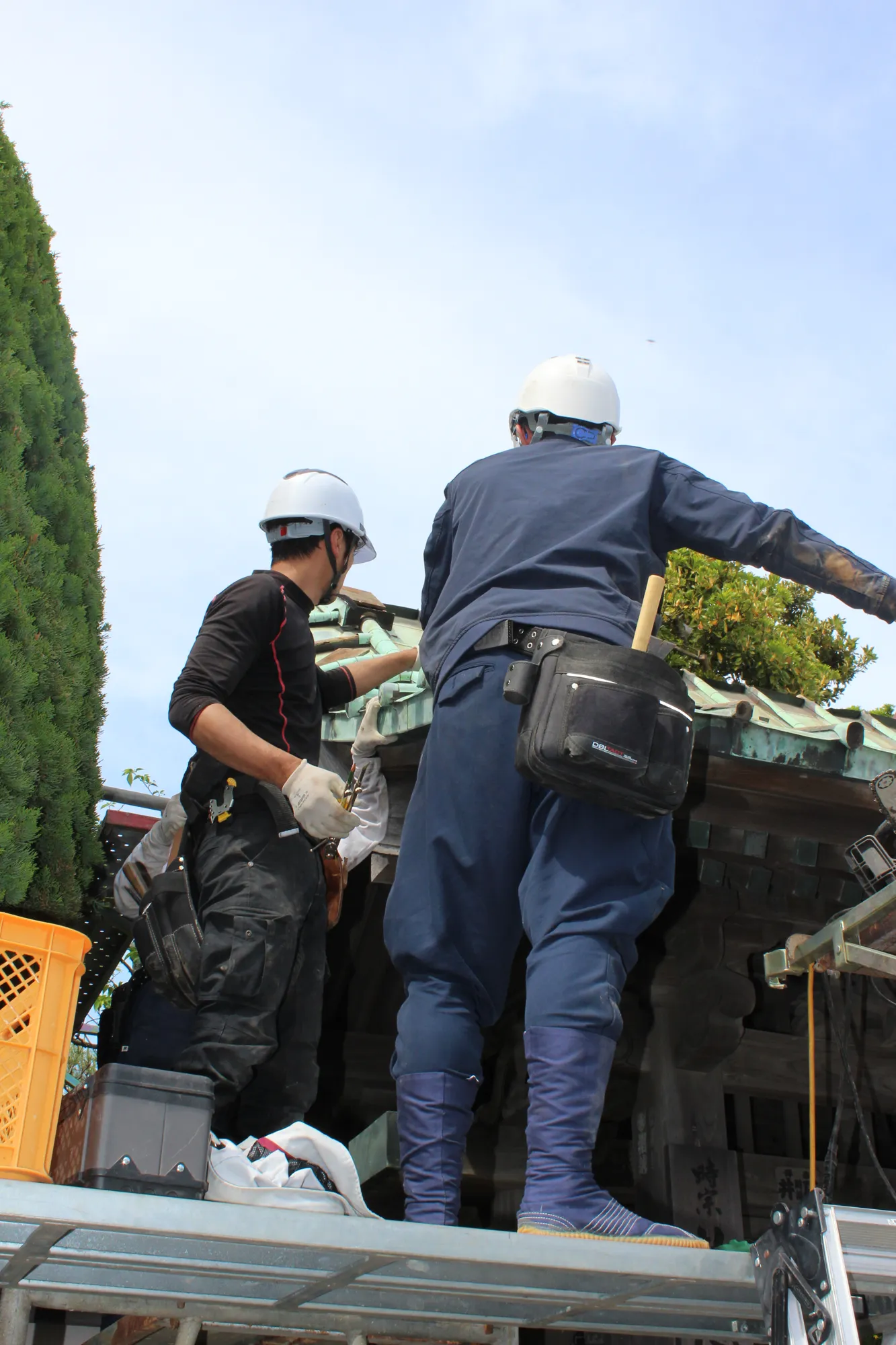 高所で作業する棟梁と弟子